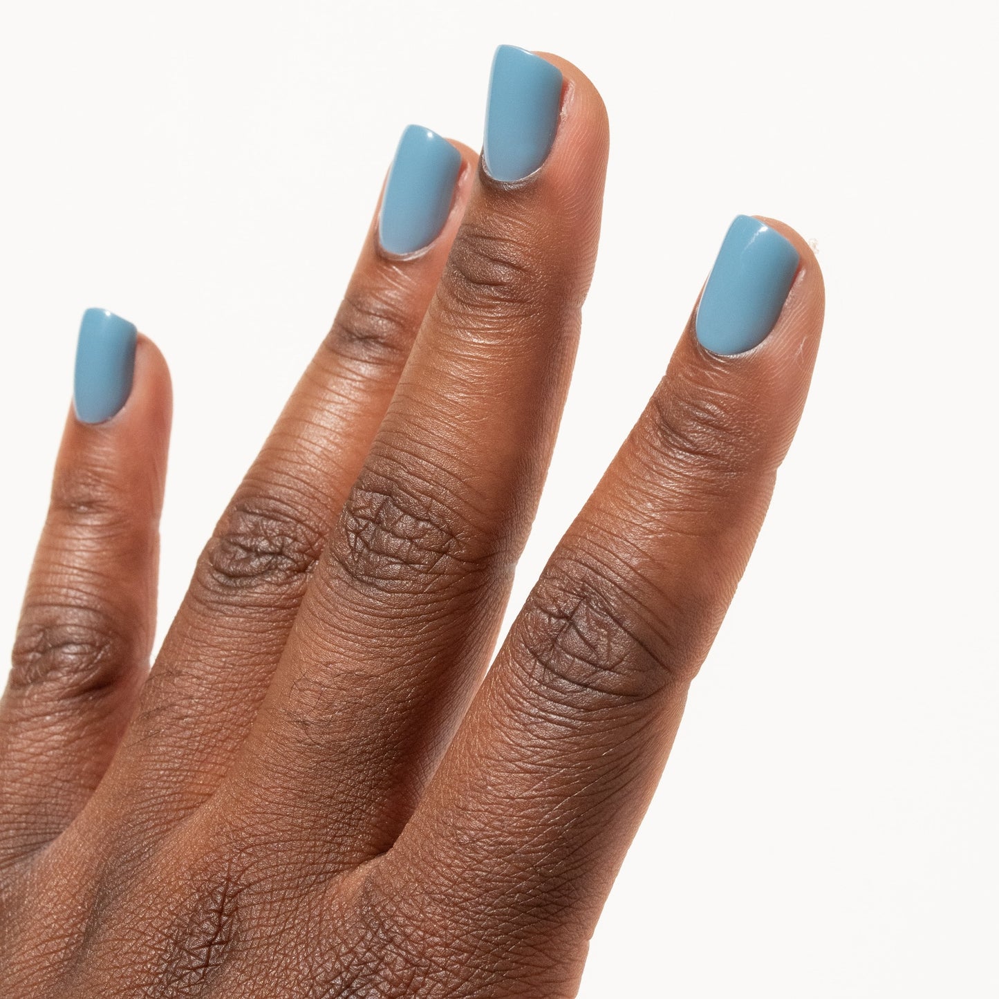 Hand with light blue press on nails on a white background