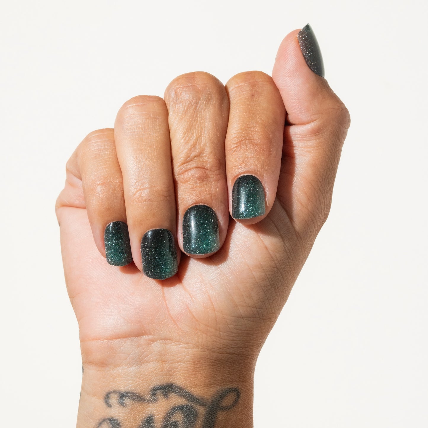 Hand with dark green press on nail on a white background
