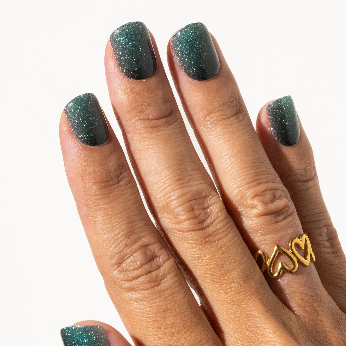 Hand with green glittery press on nails on a white background