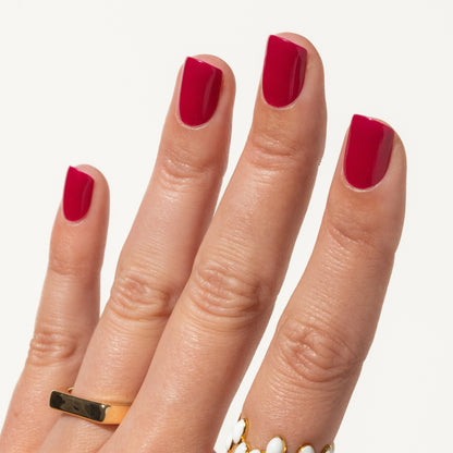 Hand with berry pink press ons on a white background