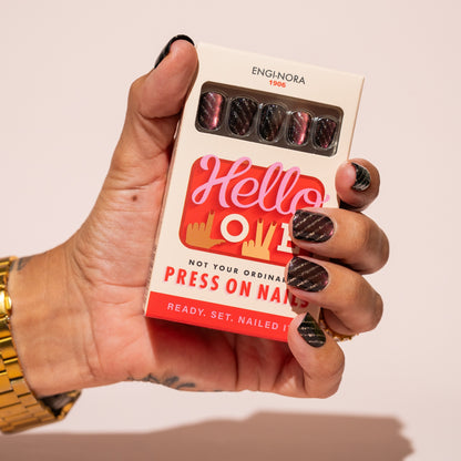 Hand holding a box of press-on nails with 'Hello Love' branding.