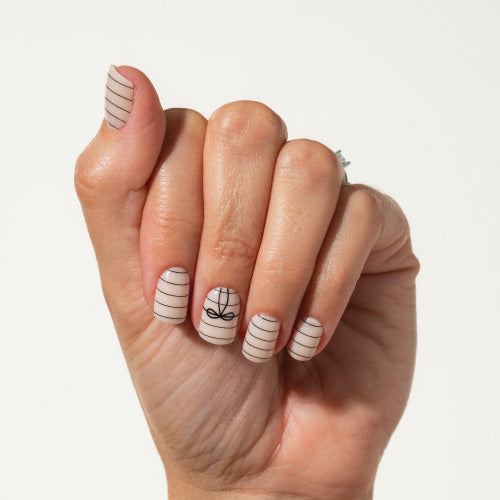 Hand with bow press on nails on a plain background