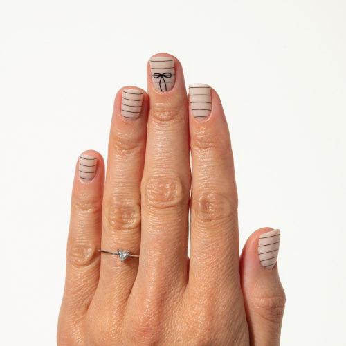 Hand with decorative nail art on a white background