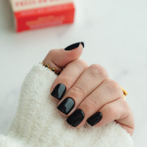 Hand with black press on nails on a white background
