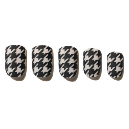 Set of five black and white houndstooth patterned press on nails on a white background