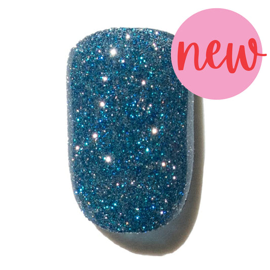 Blue glittery press on nail with a pink 'new' label on a white background