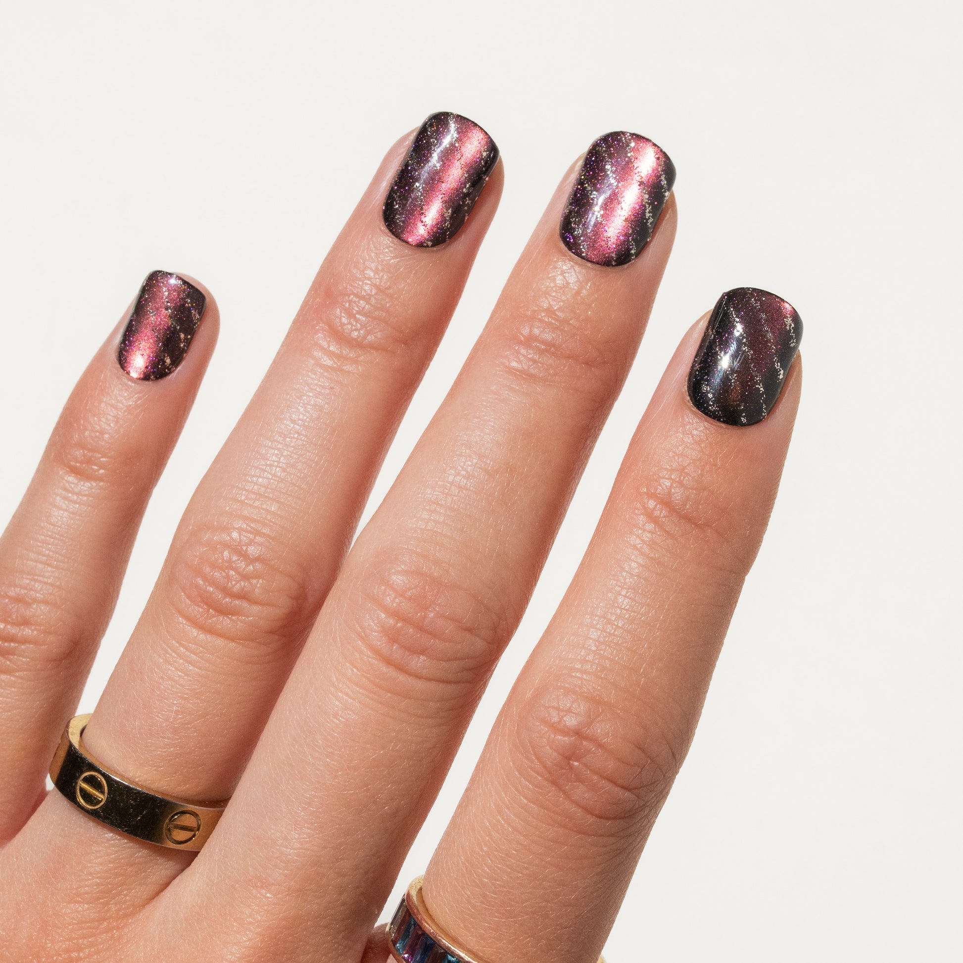 Close-up of a hand with press on nails on a light gray background