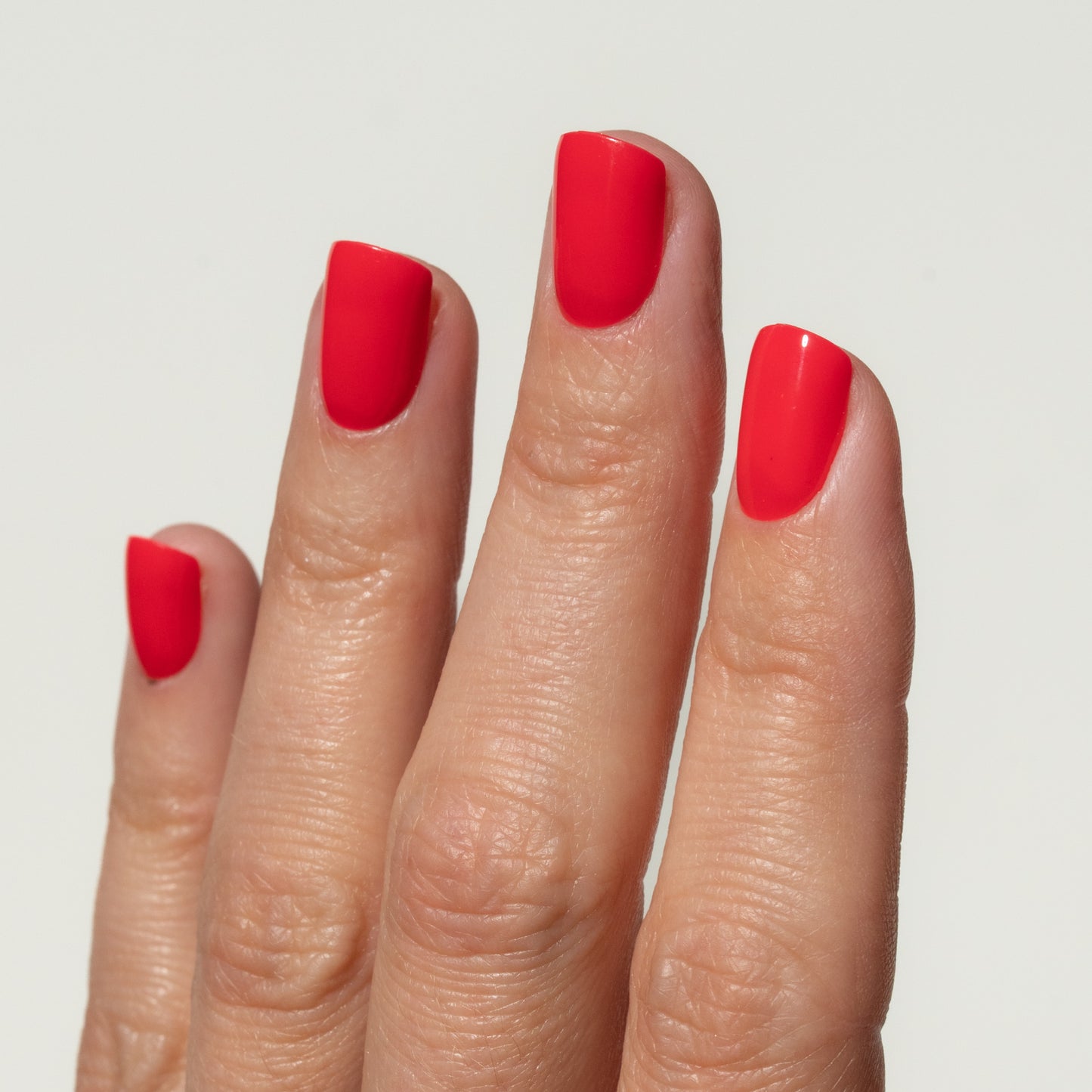 Hand with red press on nails on a plain background