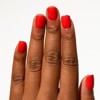 Close-up of a hand with red nails on a white background