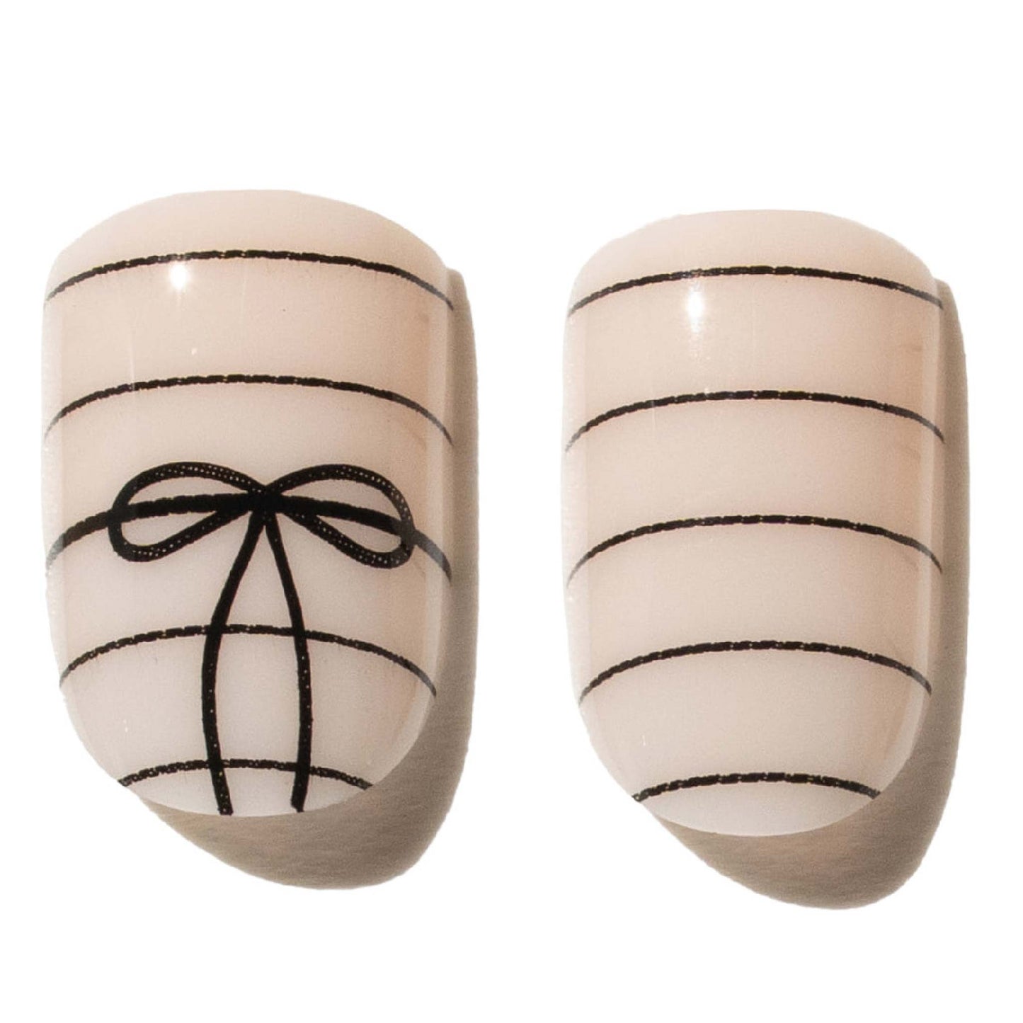 Pair of beige press on nails with black bow design on a white background