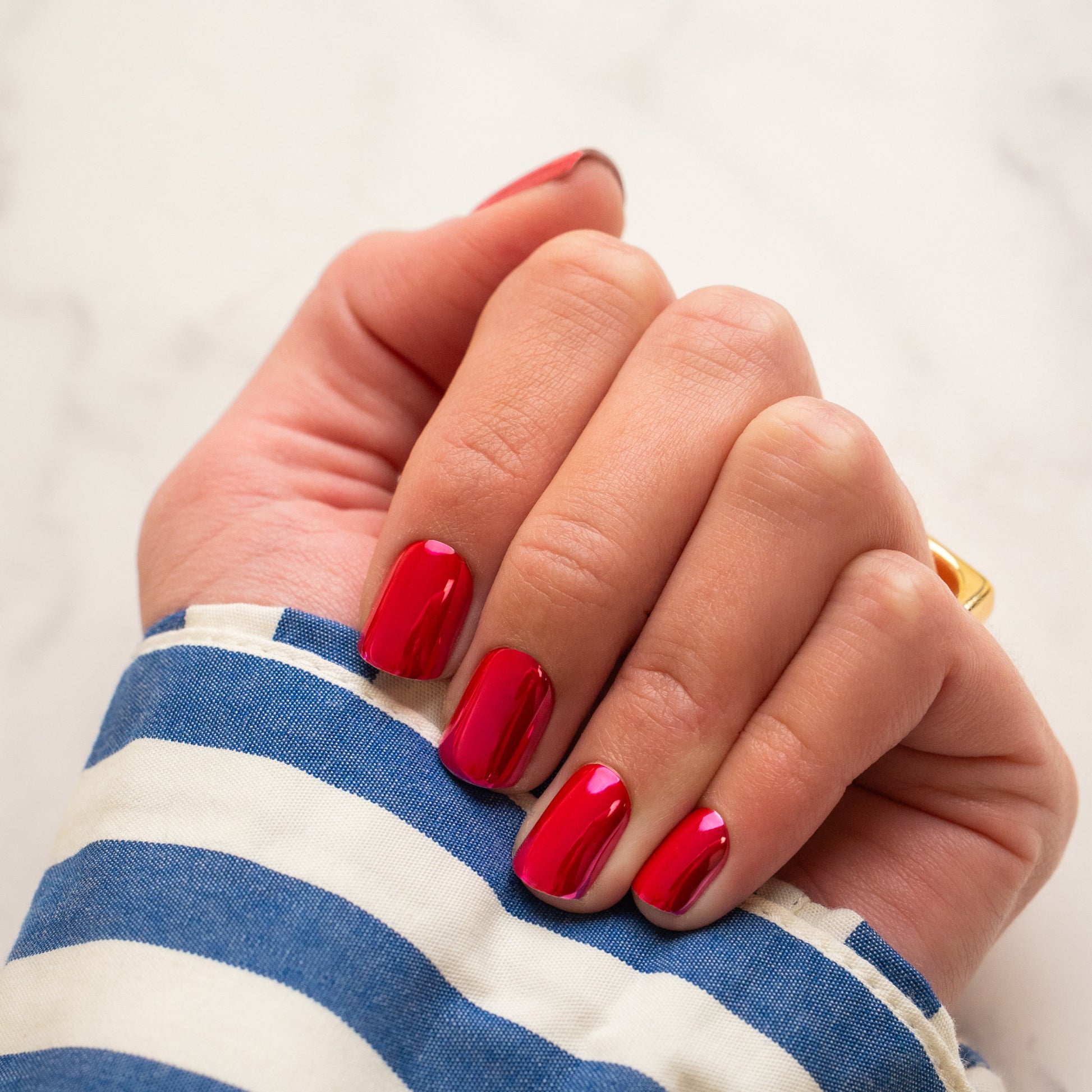Hand with pink chrome press on nails on a white background