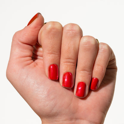 Hand with deep pink press on nails on a white background