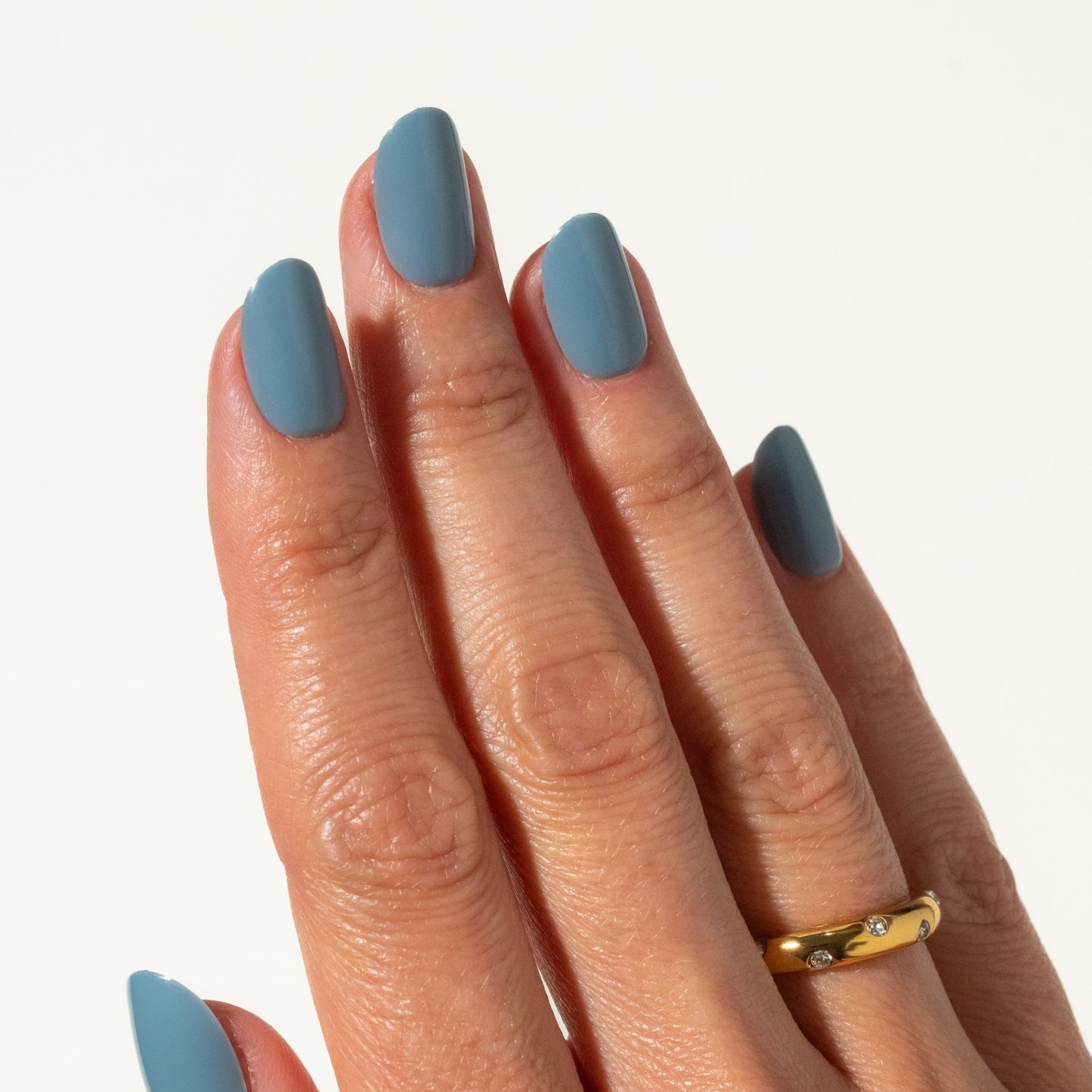 Hand with blue press on nails on a plain background
