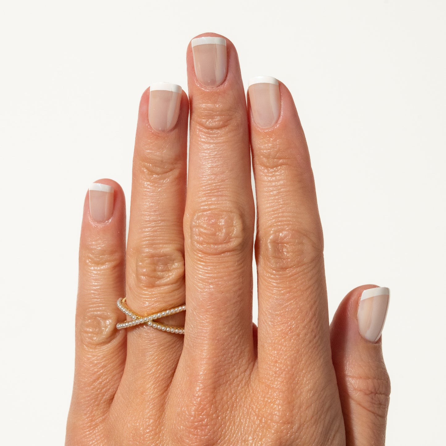 Hand with  press on nails and a silver ring on a white background