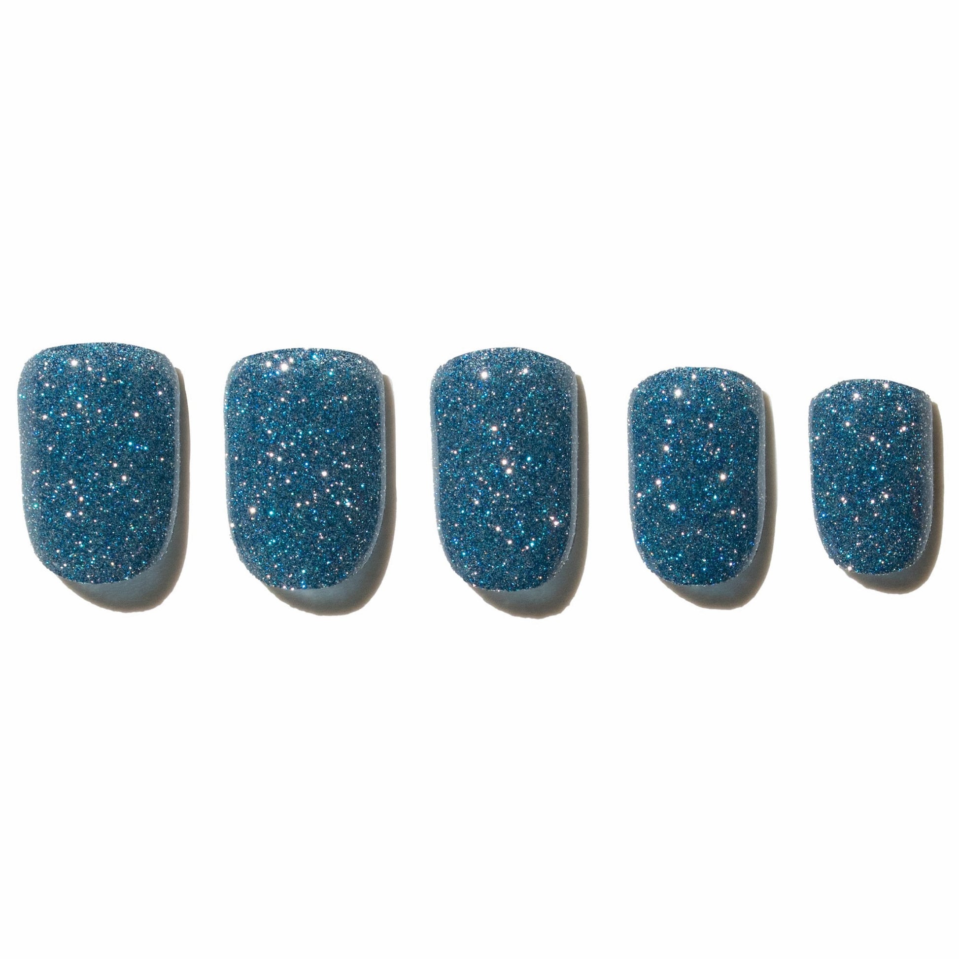 Five blue glittery press on nails on a white background