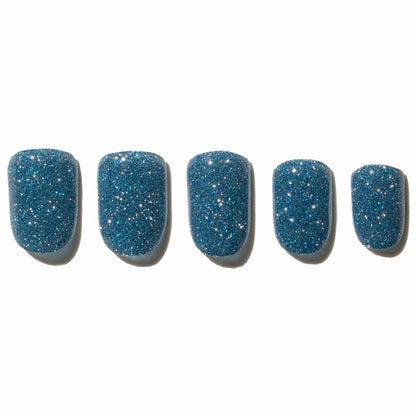 Five blue glittery press on nails on a white background