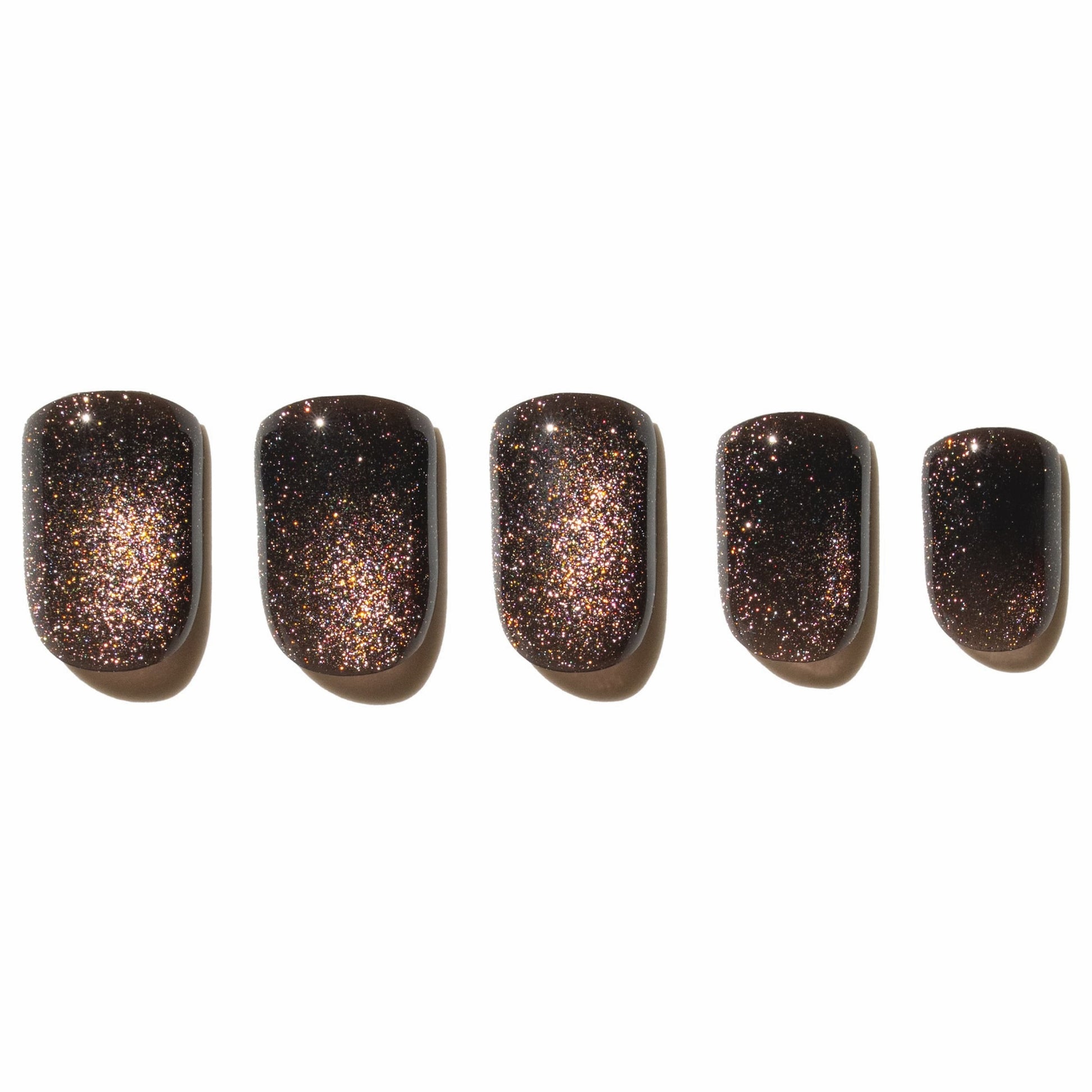 Five glittery brown press on nails lined up on a white background