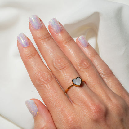 Hand with heart-shaped ring on a white background