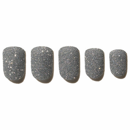 Five glittery silver press on nails on a white background