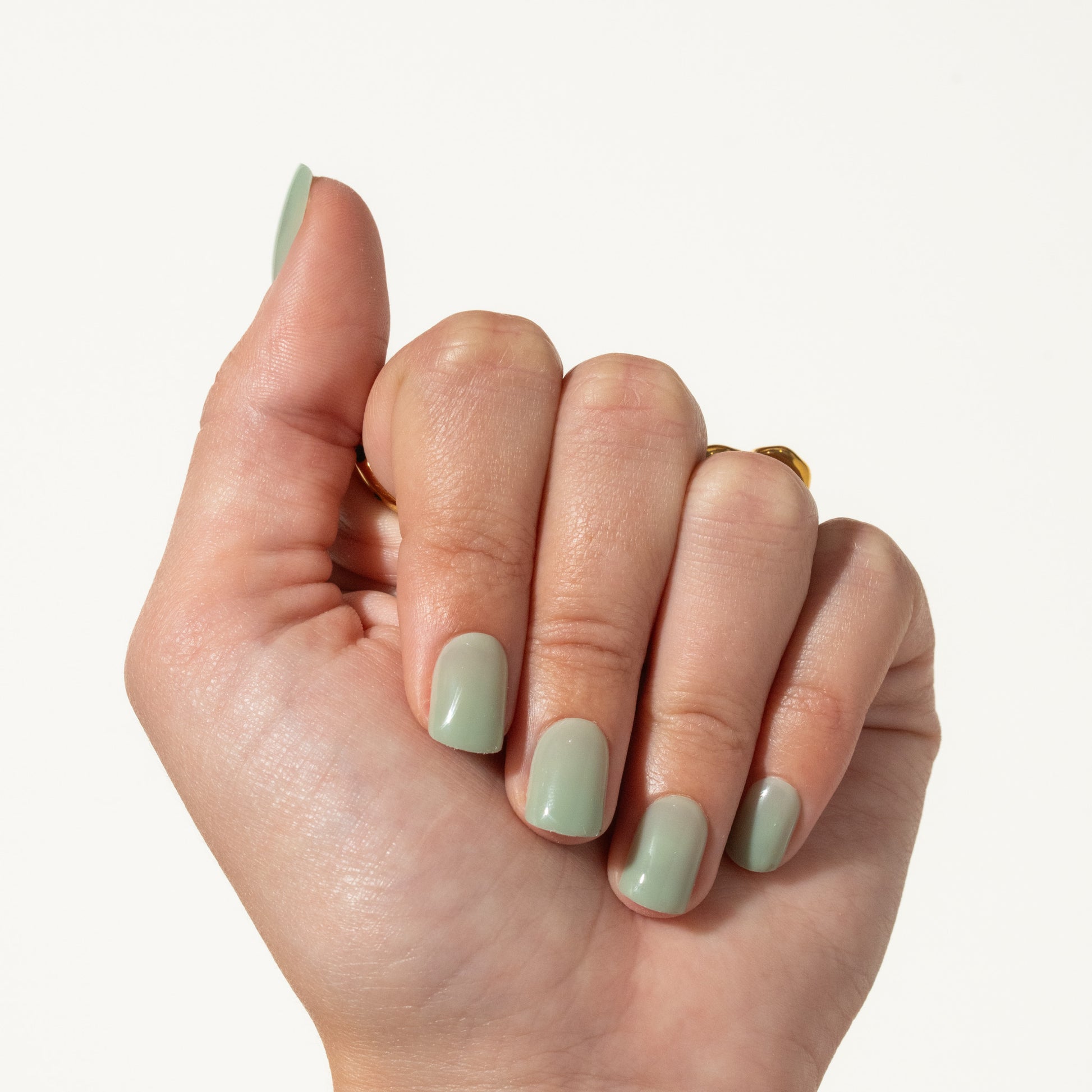 Hand with light green press on nails on a white background