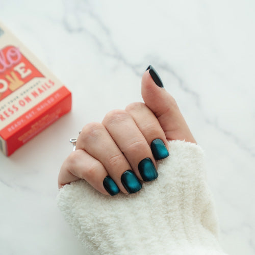Hand with teal press on nails with a red box in the background.