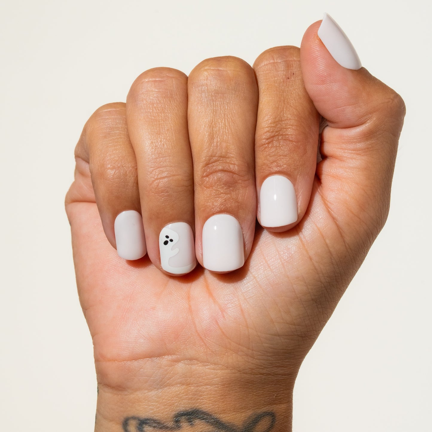 Hand with halloween press on nails oh on a plain background