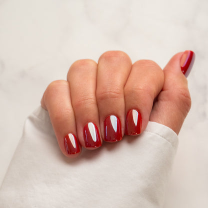 Hand with red press on nails on a plain background