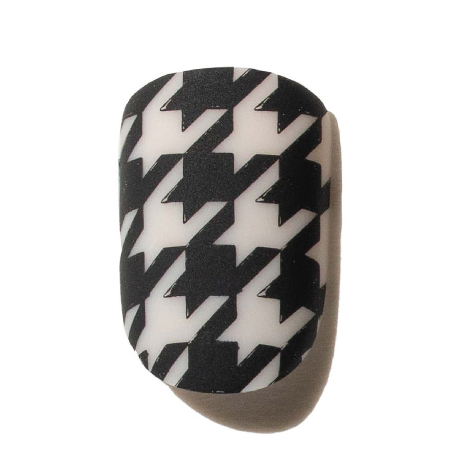 Black and white houndstooth press on nail object on a beige background