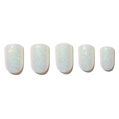 A set of four artificial nails with a white iridescent glitter finish.