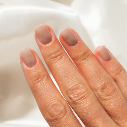 Close-up of a hand with press on nails on a white background
