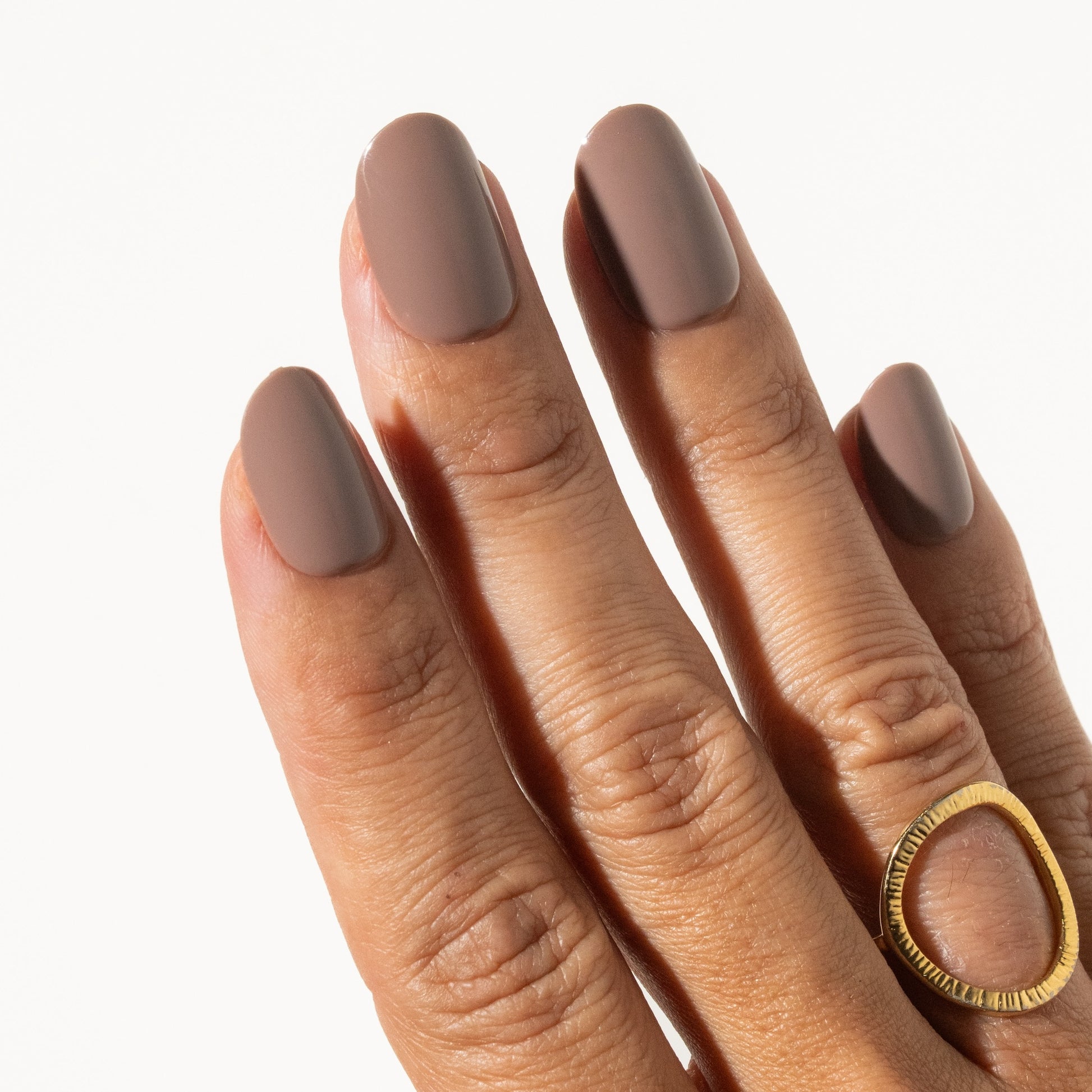 Hand with mocha brown press on nails on a white background