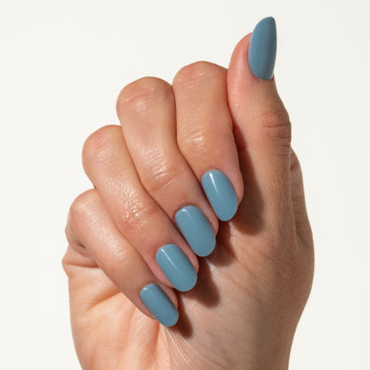 Hand with light blue press on nails on a white background