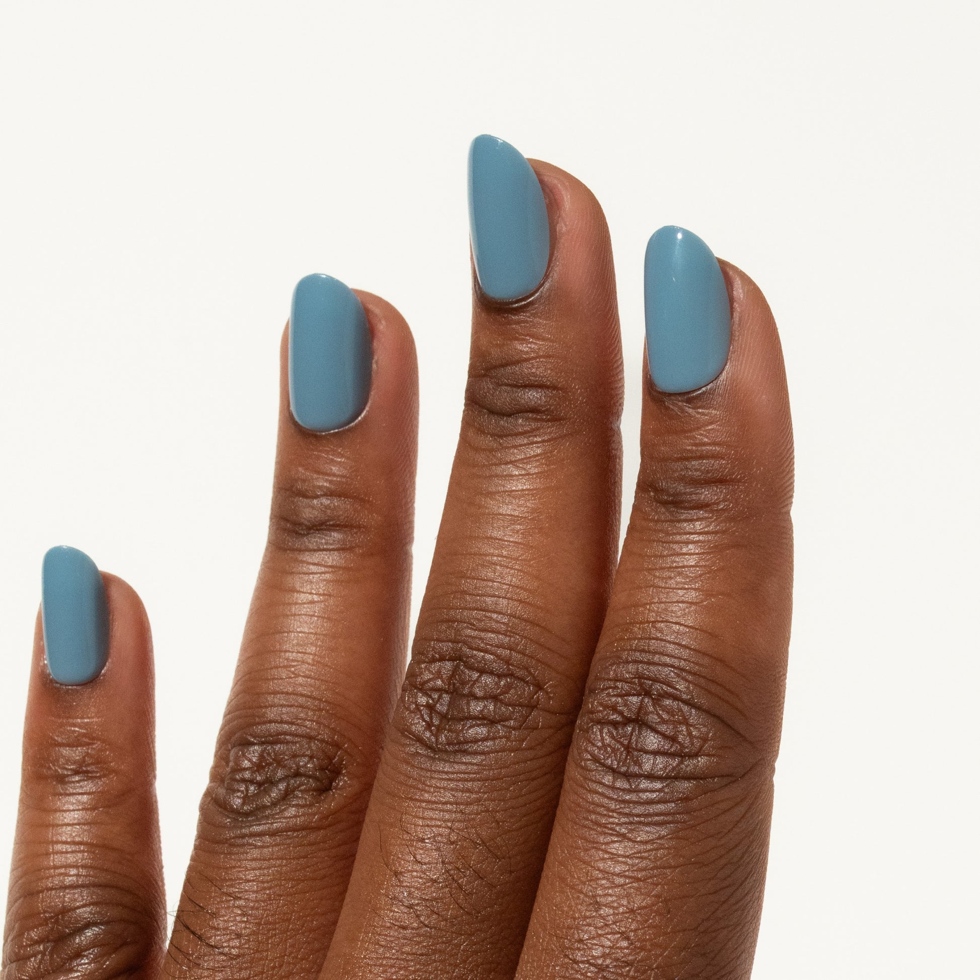 Close-up of a hand with blue press on nails on a white background