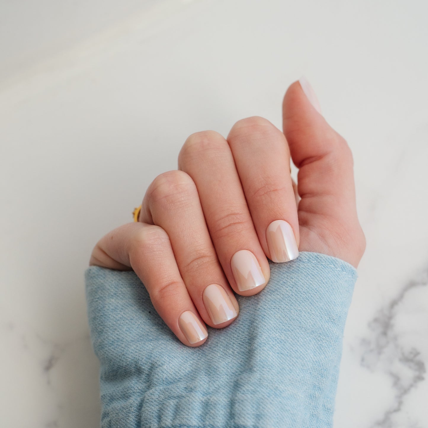 Hand with light beige press on nails on a neutral background