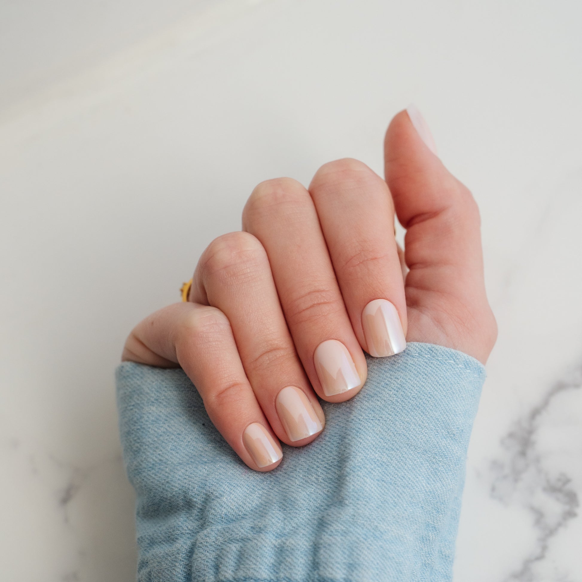 Hand with light beige press on nails on a neutral background