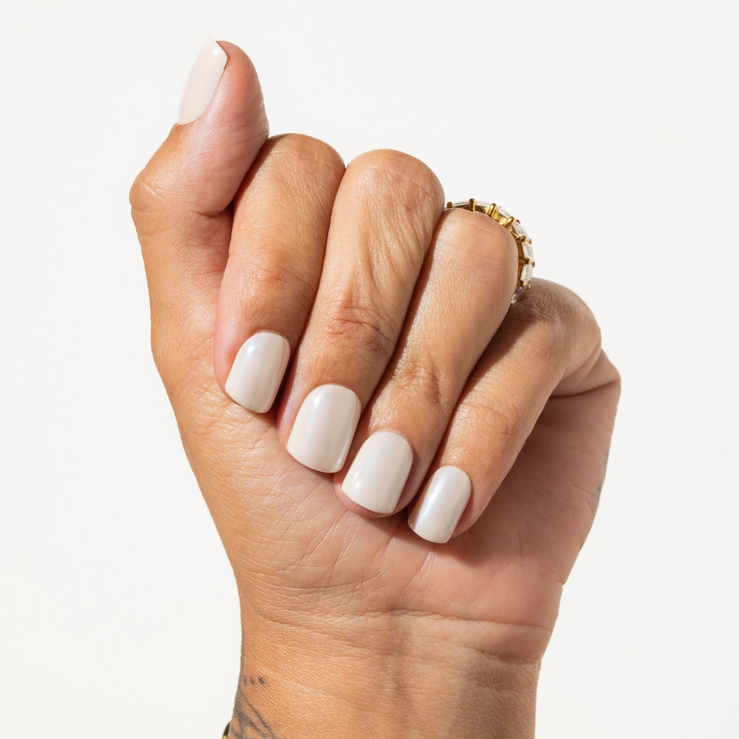 Hand with off white press on nails on a plain background