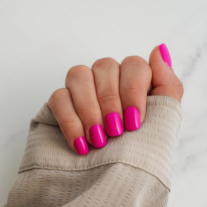 Hand with pink press on nails on a neutral background
