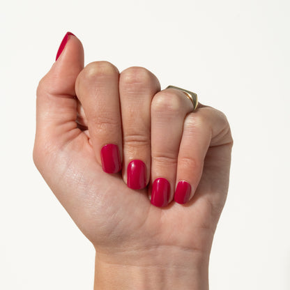 Hand with pink press ons on a white background