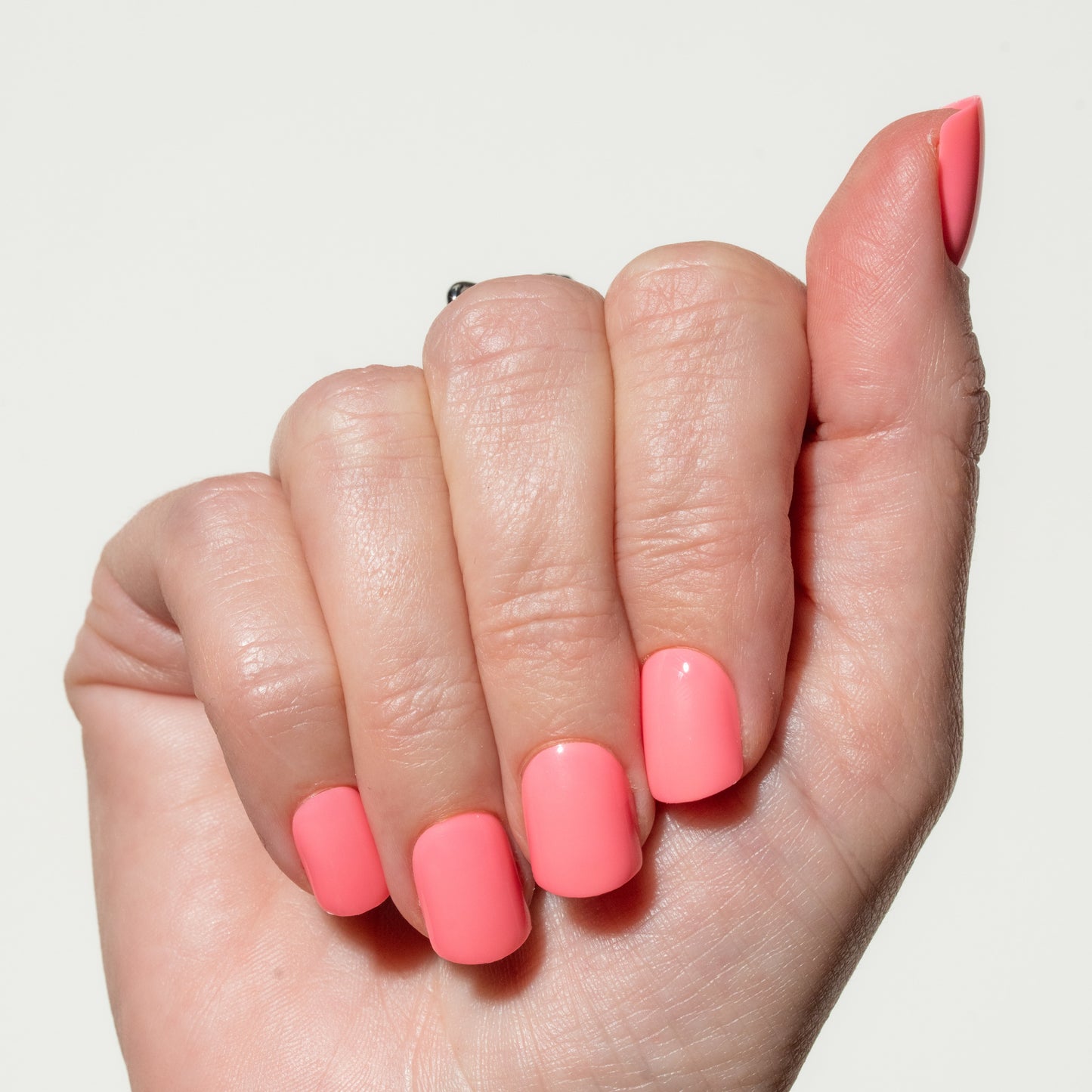 Hand with pink press on nails on a light background