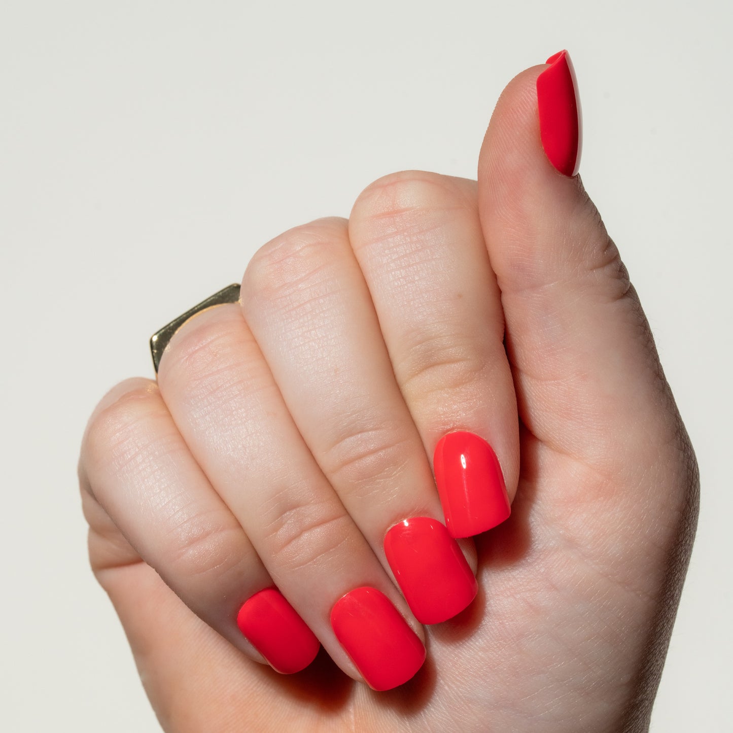 Hand with red press on nails on a light gray background