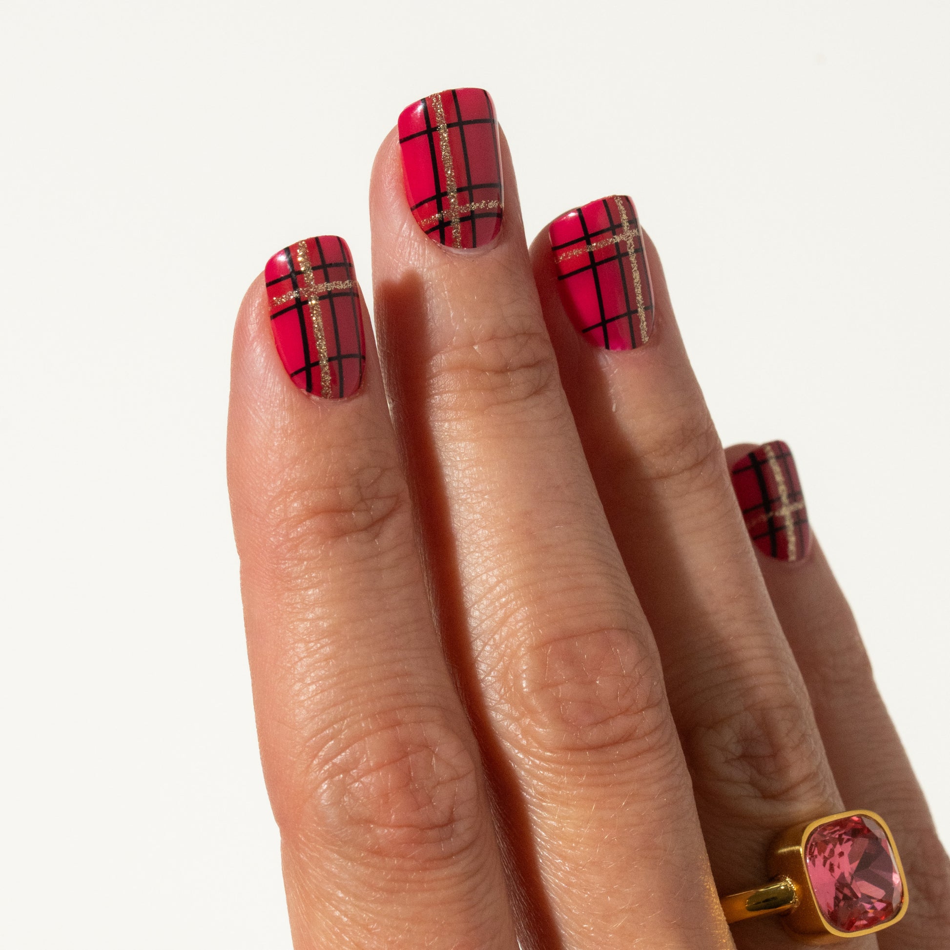 Hand with red plaid press on nails on a white background