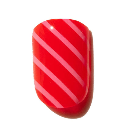Red press on nail with pink diagonal stripes on a white background