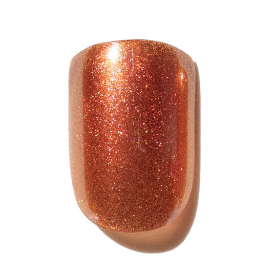 Press on nail with a glittery rose gold color on a white background