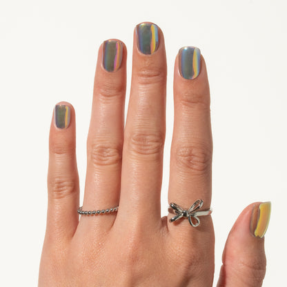 Hand with holographic gray press on nails on a white background