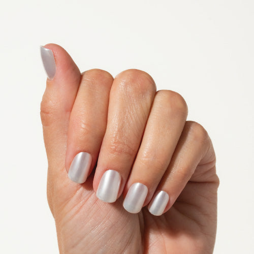 Hand with pearl press on nails on a plain background