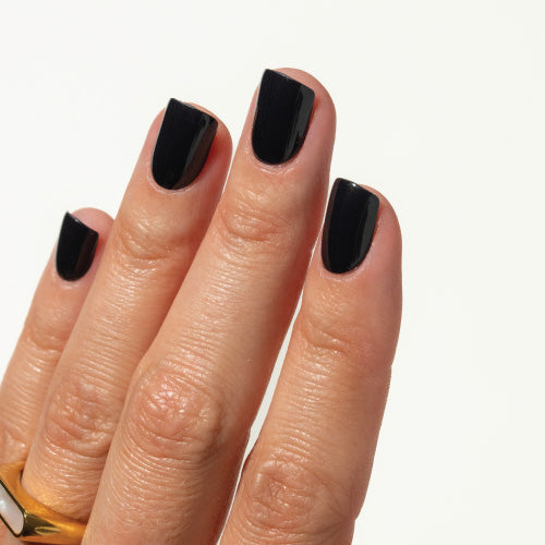 Close-up of a hand with black press on nails on a white background