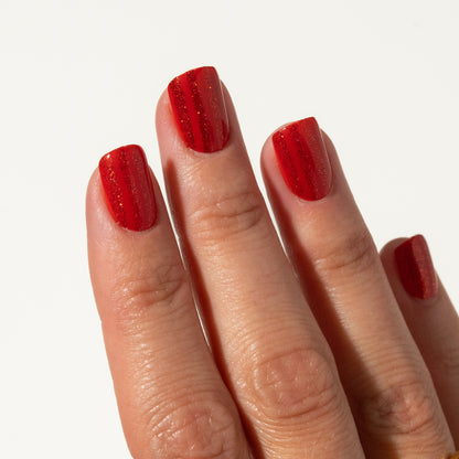 Close-up of a hand with red press on nails on a white background