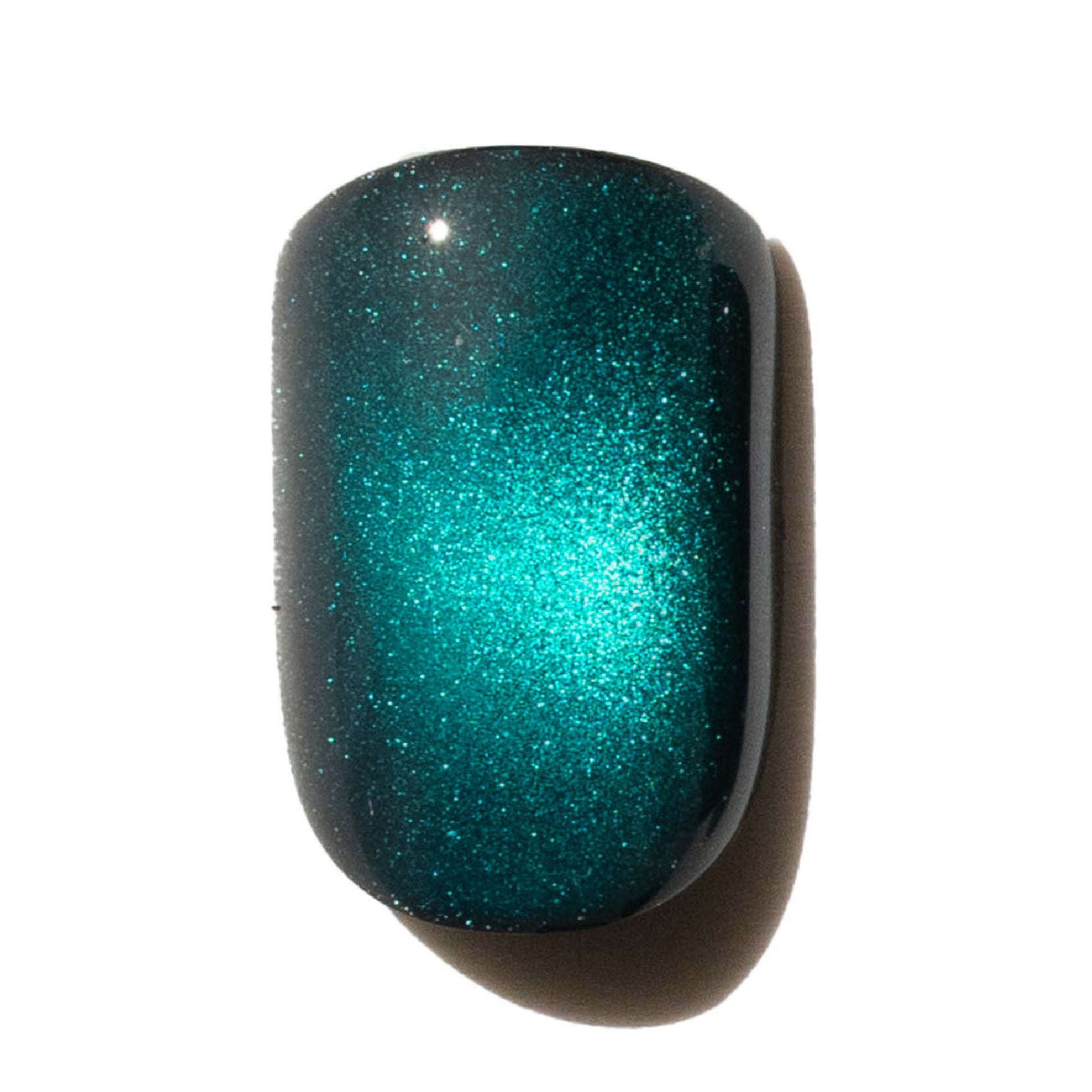 Nail with teal glittery press on nail on a white background
