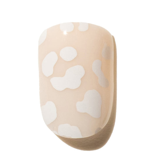 Beige press on nail with white leopard print pattern on a white background