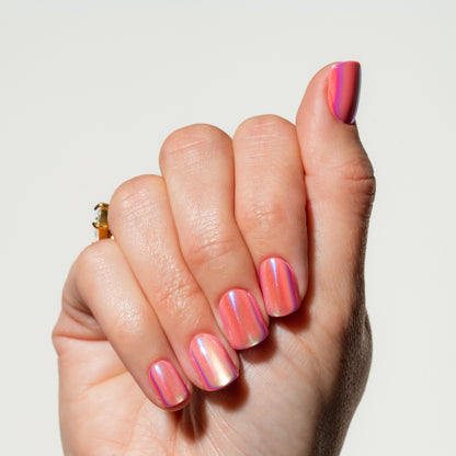 Hand with pink and purple gradient press on nails on a light background